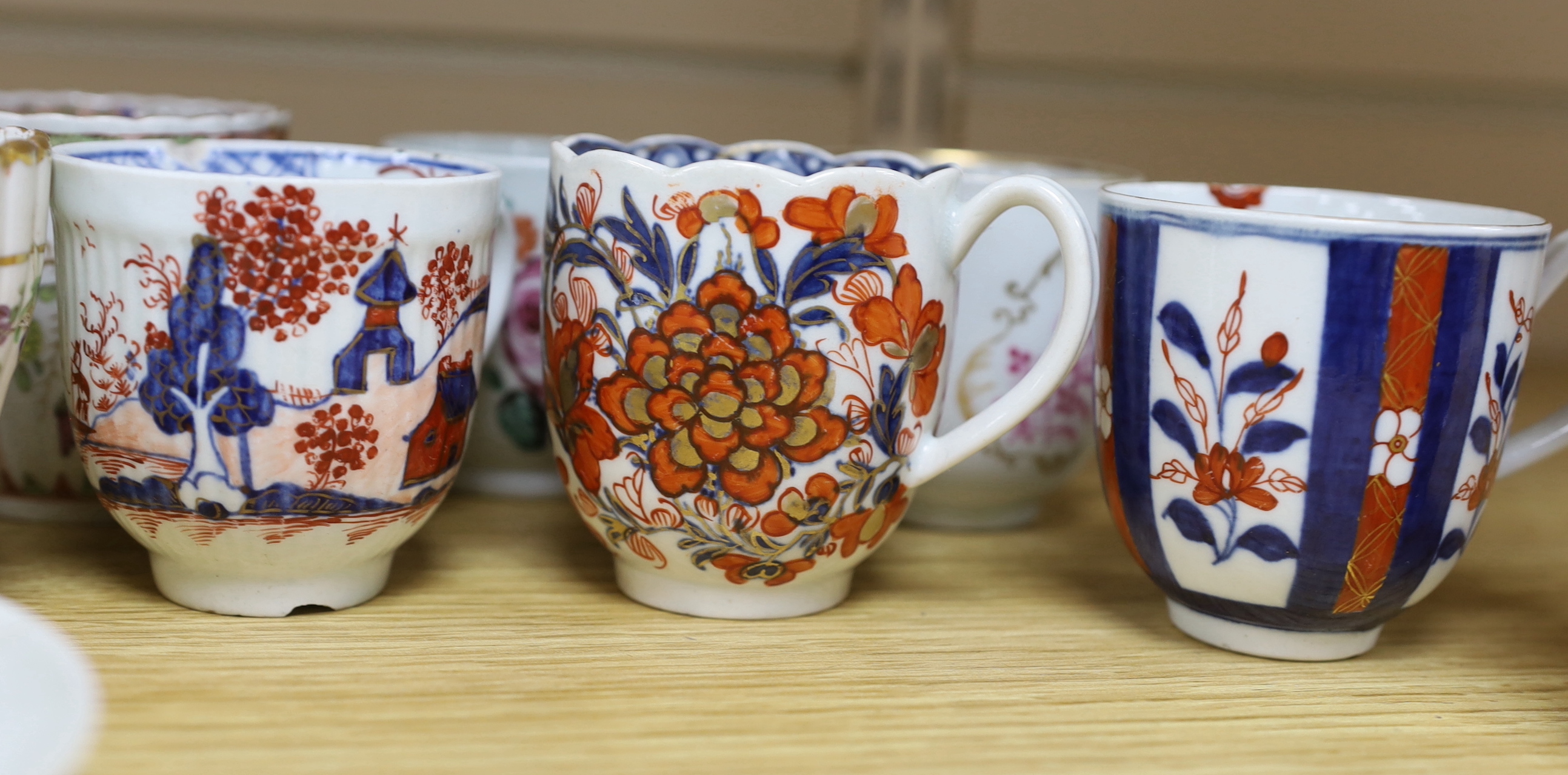 A collection of late 18th century Worcester and Lowestoft coffee cups and a saucer, many hand painted with flowers, the largest 12cm in diameter